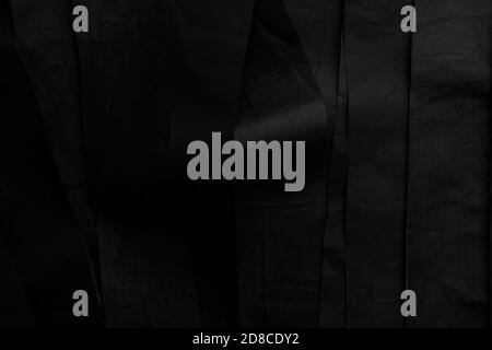 Black wavy stripes of crinkled material. Dark abstract background Stock Photo