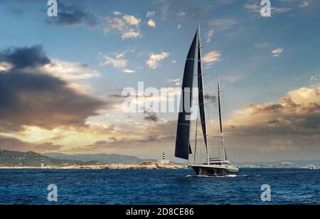 Two-masted yacht in the Mediterranean sea during bright cloudy sky sunset background. Ibiza, Balearic Islands. Spain Stock Photo
