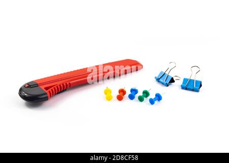 Stationery set clerical knife, pins and paper clips, on white isolated background Stock Photo