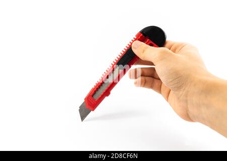 Stationery knife in hand of a man schoolboy on white isolated background Stock Photo