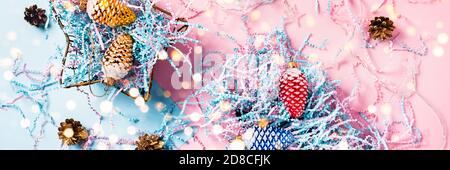 Christmas web-banner. Colored cones in a gift boxes. Christmas lights. Blue-pink background. Flat lay, top view. Stock Photo