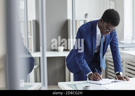African young businessman planning his business in note pad at the table at office Stock Photo