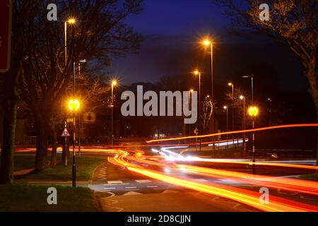 traffic passing belisha beacon flashing at zebra crossing at dusk leeds Yorkshire uk Stock Photo