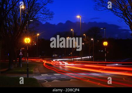 traffic passing belisha beacon flashing at zebra crossing at dusk leeds Yorkshire uk Stock Photo