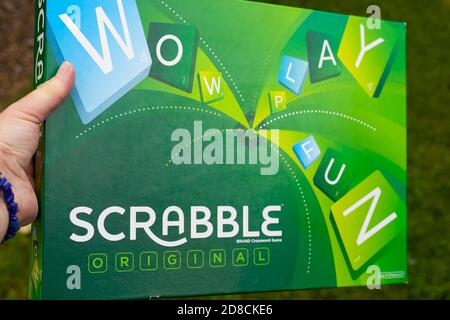 High-Resolution close-up of hand holding Scrabble Original Board Game Stock Photo
