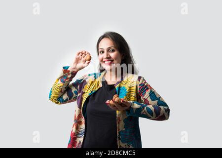 Pretty Asian Indian young girl showing dry fruits like Cashew, Almond or walnut - healthy eating concept Stock Photo