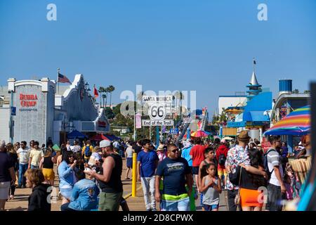 Route 66 Sign amongst crowds of people, Santa Monica Pier, California, USA Stock Photo