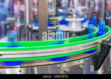 Clear blue glass bottles transfer on Automated conveyor systems industrial automation for package Stock Photo
