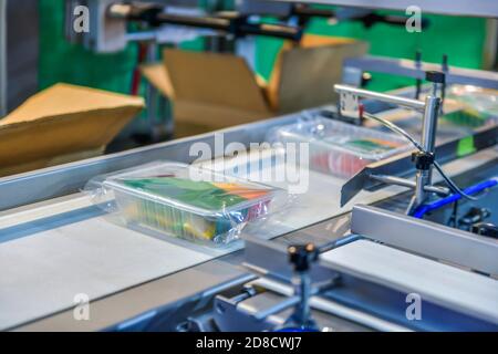 Box with food on conveyor belt in distribution warehouse. parcels transportation system concept Stock Photo