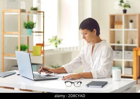 Young business woman sitting and working on laptop in office Stock Photo