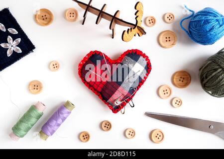top view of sewing set for tailor shop with thread, scissors, buttons and needle pillow on white background, flat lay Stock Photo