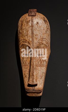 Santa Cruz de Tenerife/Spain; March 22 2019: Antique african Fang Ngil wooden mask, from Gabon, on grey wall surface Stock Photo