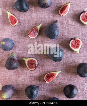 fresh cut and whole figs lying on pink textured background  Stock Photo