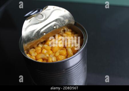 yellow sugar corn in a tin metal can on a dark background of copy space Stock Photo