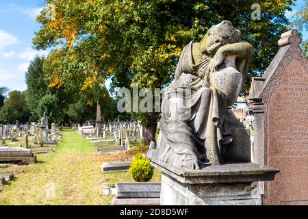 Funerary monument of mourning woman at Kensal Green Cemetery in autumn, London, UK