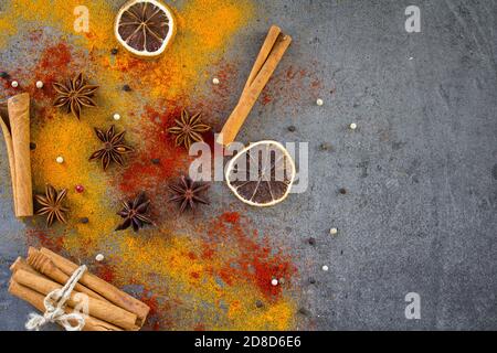 Different spices on a table. Top view photo of cinnamon, curcuma, lemon, anise and paprika. Gray background with copy space. Stock Photo