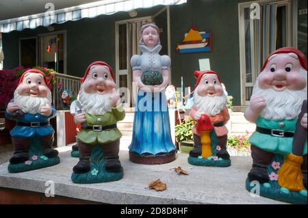 statues of Snow White and the dwarfs in a garden of a house Stock Photo