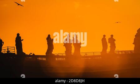 Sculptures of saints in Vatican, silhouette on the orange background, panorama Stock Photo