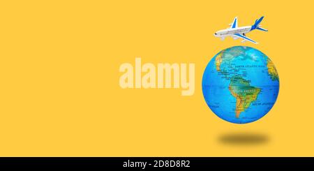 Plastic toy plane on the globe. Flight travel concept. Travel by airplane. Takeoff and landing of the aircraft. Return home from flight. Long wide ban Stock Photo