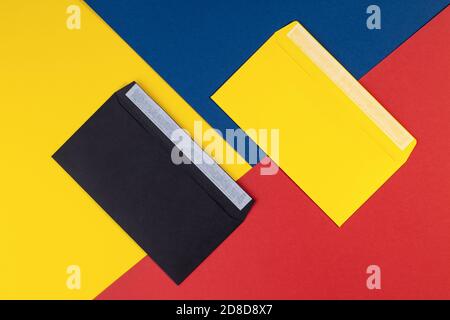 Black and yellow envelopes on multicolored paper background. Geometry background minimal concept. Multicolored paper with envelopes. Creative flat lay Stock Photo