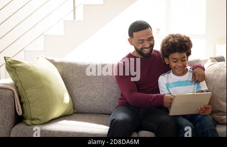 Man and son using digital tablet at home Stock Photo
