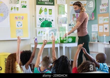 Students raising hands in class at school Stock Photo