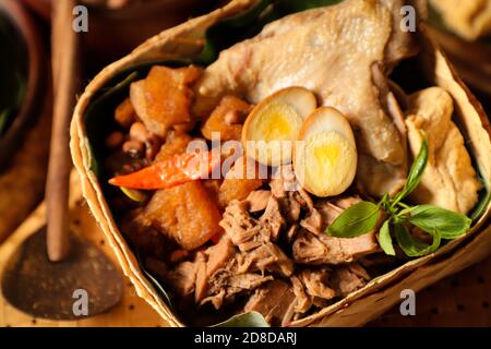 Gudeg Jogja. Javanese dish consists of jack fruit stew, chicken curry and spicy stew of cattle skin crackers in bamboo basket Stock Photo