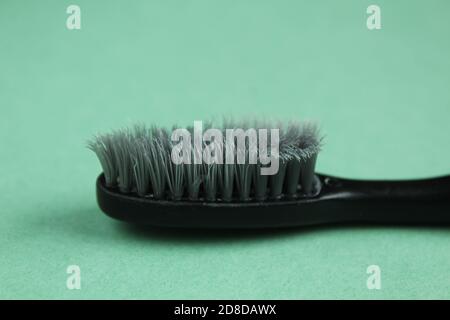 toothbrush black gray old used on a green grass background copy space Stock Photo