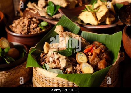 Gudeg Jogja. Javanese dish consists of jack fruit stew, chicken curry and spicy stew of cattle skin crackers in bamboo basket Stock Photo