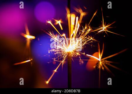 Christmas sparkler close up, Bengal light on blue background. Stock Photo