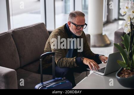Serious bearded man using his computer indoors Stock Photo