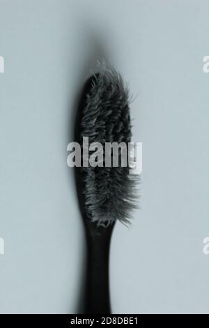 toothbrush old used black grey on light grey background copy space Stock Photo