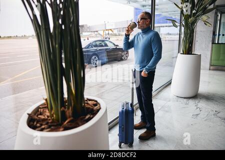 Pensive man drinking coffee from a disposable paper cup Stock Photo