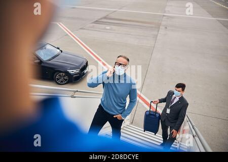Businessman talking on the smartphone on the passenger boarding stairs Stock Photo