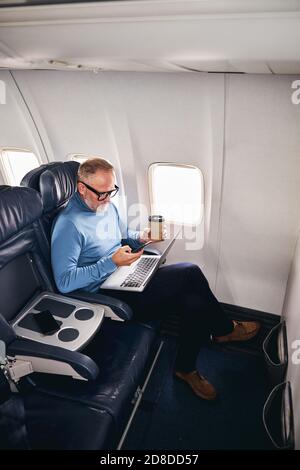 Concentrated airline passenger working during the flight Stock Photo