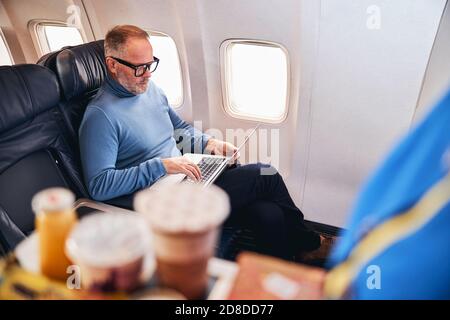 Air traveler using his computer on the plane Stock Photo
