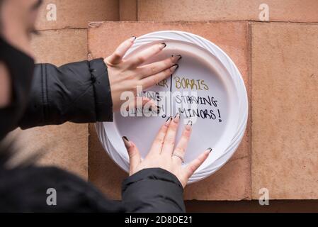 London, UK.  29 October 2020.  A woman takes part in a protest outside the Department for Education in Westminster by affixing paper plates with messages directed at the UK government to reconsider their recent decision not to provide free school meals until Easter 2021.   Footballer Marcus Rashford’s campaign to provide school meals continues to receive public and business support.  Credit: Stephen Chung / Alamy Live News Stock Photo