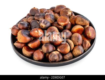 Roasted chestnuts on a round plate  isolated on white background. Healthy nuts closeup Stock Photo