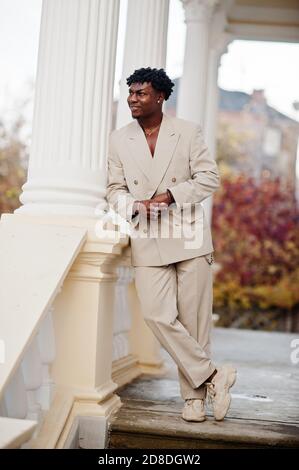 Stylish afro man in beige old school suit. Fashionable young