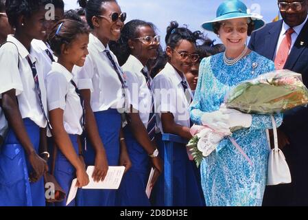 A line of local students and pupils greet HRH Queen Elizabeth II on her ...