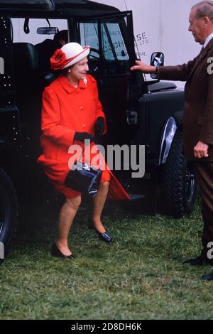 The Queen facing an ungainly long leap from her Land Rover Four-wheel Drive vehicle as she arrives for The Royal Windsor Horse Show At Windsor Castle. Berkshire, England, UK 1989 Stock Photo