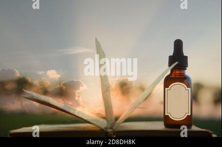 Essential oil and aromatherapy book, concept - MOCKUP. Magic book and herb bottle, empty label. Stock Photo