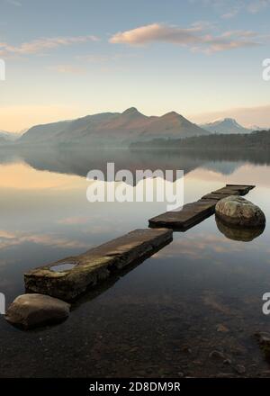 Mirror-like reflections of Cumbrian mountains with beautiful blue morning sky. Taken at Derwentwater in the Lake District, UK. Stock Photo