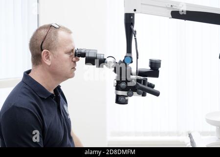 Dentist working with dental microscope Stock Photo