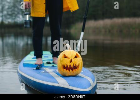 pumpkin on inflatable Board with paddle, sup surfing in autumn Stock Photo