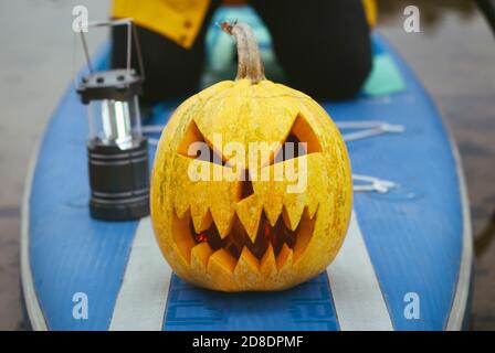 pumpkin on inflatable Board with paddle, sup surfing in autumn Stock Photo