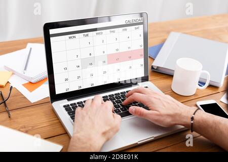Man Working With Calender Planner On Laptop In Office, Managing Business Schedule Stock Photo