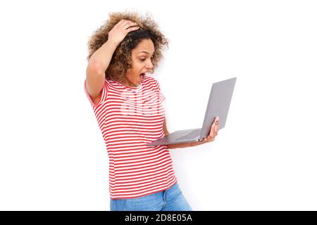 Surprised young african american woman holding laptop with mouth open Stock Photo