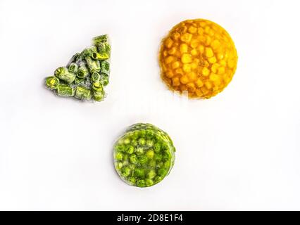 Frozen vegetables close-up on a white background Frozen corn, green peas, chopped green beans Copy space vegan food sustainable eco friendly concept Stock Photo