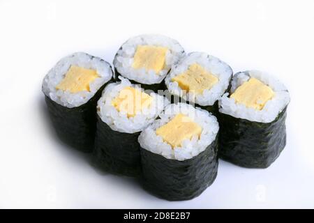 Japanese sushi maki on black stone Maki Tamago on a white background. Roll ingredients: tamago omelet, nori, rice Stock Photo